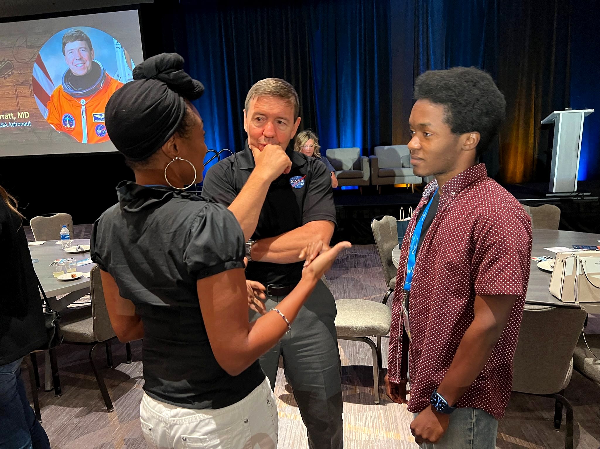 Three people deep in conversation at an HA conference