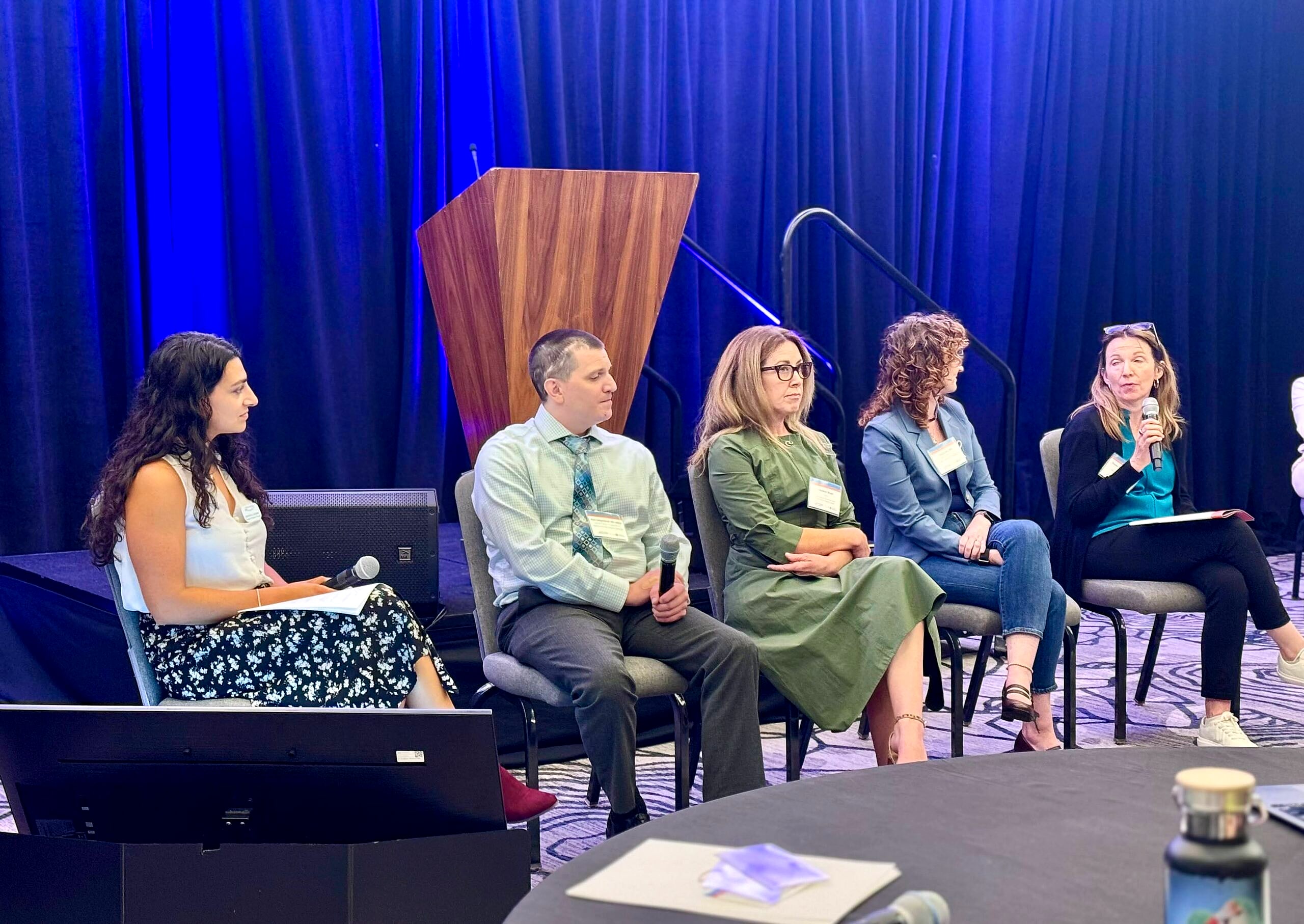 A panel of speakers taking questions on stage at an HA conference